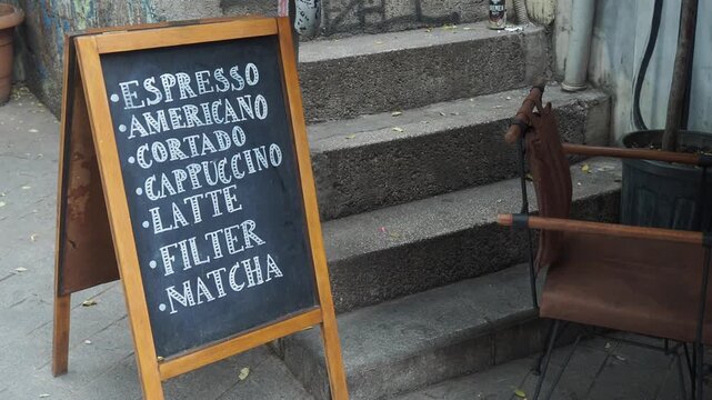 Menu board shows drinks at a cafe on a busy street