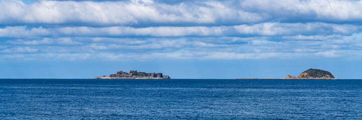 Fototapeta premium Distant view of Gunkanjima island floating on the calm sea