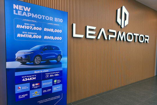 Penang, Malaysia - Feb 20, 2026: A large blue promotional banner for the Leapmotor B10 electric SUV next to a backlit Leapmotor brand logo on a wood-slatted wall.
