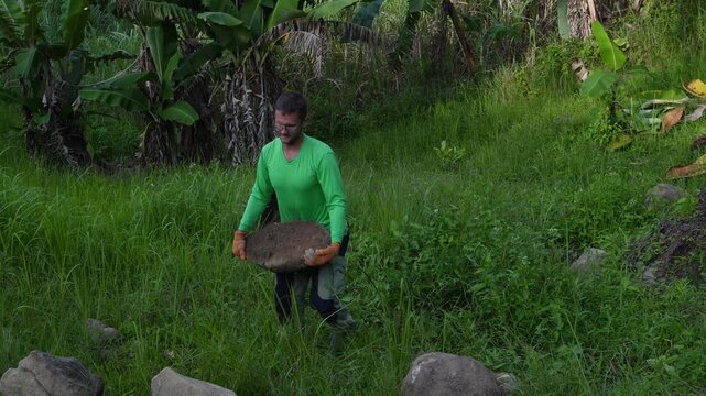 A man carrying a big stone 