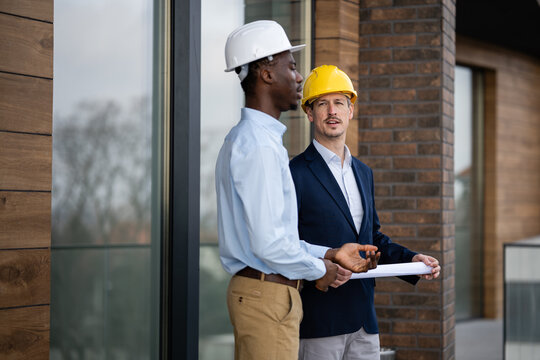 Architects discussing construction plan on building site