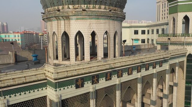 Ascending drone shot of Chinese Islamic mosque reveals skyline of Xining city
