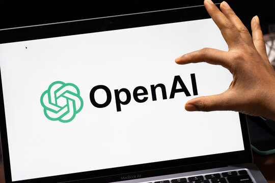 In this photo illustration, a smartphone displays the Sora AI logo in landscape orientation, with the OpenAI logo visible in the background