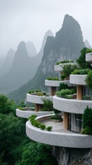 Fototapeta premium Curved terraces of a contemporary building stand against a backdrop of towering, mist-covered mountains. Lush greenery complements the elegant design, promoting relaxation in serene surroundings