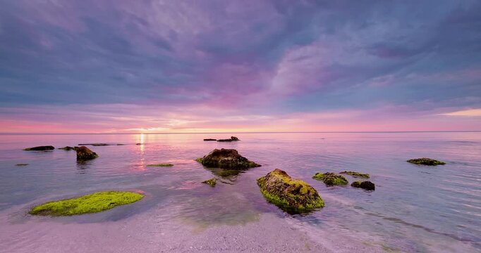Beautiful cloudscape over the sea waves and rocky beach  sunrise video