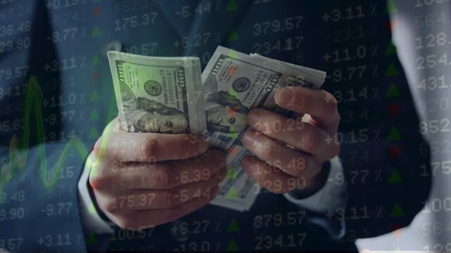 Businessman counting US dollar bills overlaid with fluctuating stock market ticker numbers and financial line charts. Currency exchange and economy.