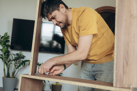 Father assembling furniture at home focusing on DIY task