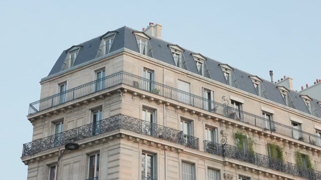 Traditional Haussmann Architecture Apartment Building with Wrought Iron Balconies and Mansard Roof in Paris, France