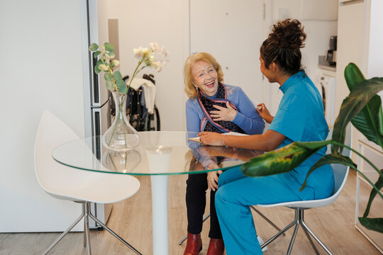 Caregiver assisting senior woman during home medical checkup