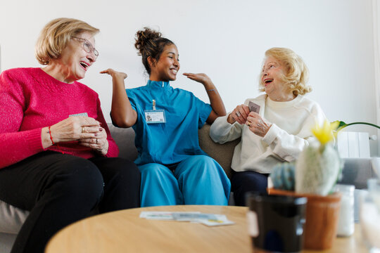 Caregiver and seniors enjoying conversation and therapy indoors
