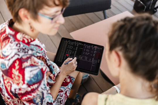 Business discussion with tablet analyzing stock market data indoors