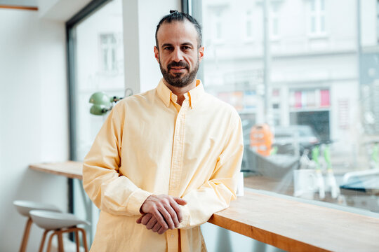 Self-employed developer standing indoors by window in workspace