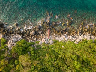 Aerial View of Wooden Bridge on Rocky Coastline with Golden Morning Light and Turquoise Sea Ko Tao Thailand © Anton
