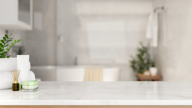 White towel with diffuser and cream jar on marble counter table across tub in modern luxury bathroom