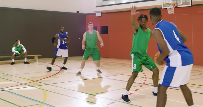 On inbound at basketball court, african american male player #4 dribbling, and passing to #12 for sh