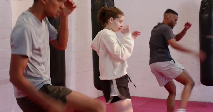 At drill start Diverse training partners punching and front kicking on red mat for skill practice