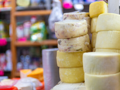 Close Up Stacked Round Cheese Variety Displayed at Local Market