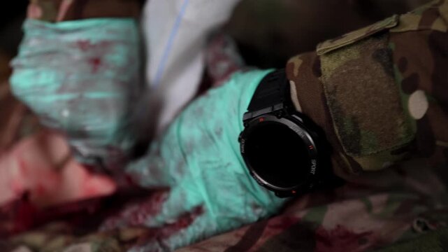 Close-up horizontal shot of a combat medic's hands in blue gloves performing life-saving wound packing by stuffing medical gauze into a deep injury to achieve hemostasis