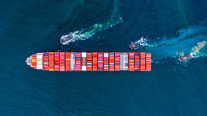 Aerial top view tugboat pushing container cargo ship going to yerminal commercial port for business logistics. © Teppakorn