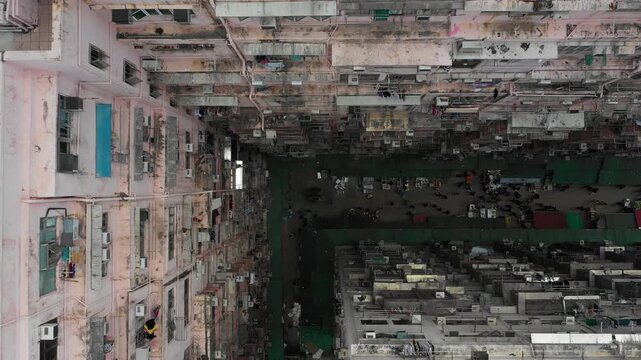 Aerial view of subsidized housing and people buying groceries at local market in Hong Kong
