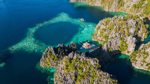 aerial drone view of the circular Barracuda Lake in Coron, Palawan. A stunning turquoise lagoon hidden within massive limestone karst formations in the Philippines