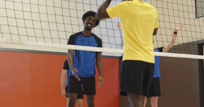 Blue blocker blocking, shaking hands with yellow team at gym net after point showing fair play