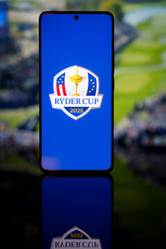 Ryder Cup 2025 logo displayed on a smartphone screen with a blurred golf course background, representing international golf competition and mobile sports broadcasting