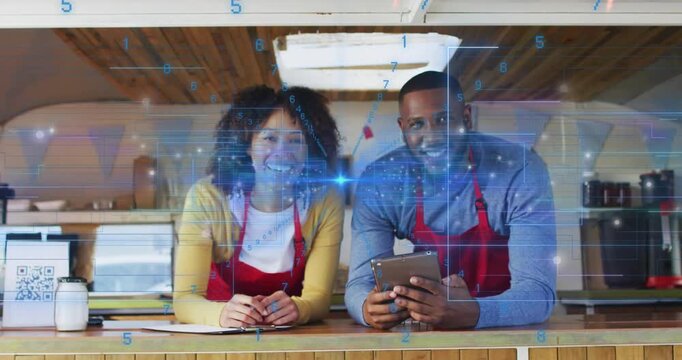 Vertical video: Blue overlay drifting two in red aprons scrolling tablet holding pen at counter