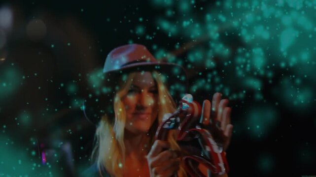 Vertical video: Singer raising arms shaking tambourine on stage teal particles accenting music