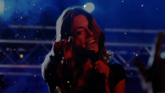 Right performer raising arm, camera shifting to lead singer moving singing reaching engaging crowd