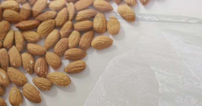 Vertical video: Shifting camera refocusing over almonds on plate, revealing texture on thin film
