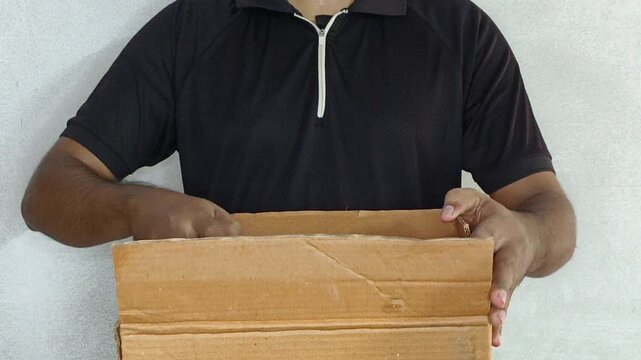 Person hand opening brown cardboard or carton box parcel package to check inside product. Online shopping, ebusiness, quick commerce, supply chain, courier delivery and ecommerce business concept.