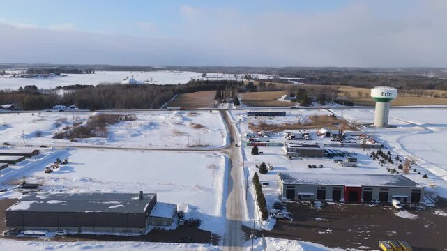 Industrial Businesses And Water Tower In A Winter Landscape At Erin In Ontario, Canada. Aerial Flyover.