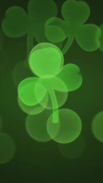 Slow motion pan of glowing shamrock shapes drifting over dark green bokeh background for st patrick poster design