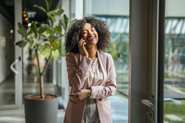 Smiling businesswoman talking on mobile phone in office