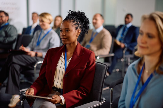 Black female entrepreneur attending business conference at convention center.
