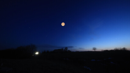 Fototapeta premium Full Moon, stars and planets above landscape silhouettes.