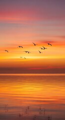 Obraz premium Birds flying over serene sunset ocean.