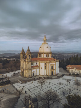Aerial view of the imposing Santuario de Nossa Senhora do Sameiro under a dramatic sky, its dome and towers a beacon against the landscape, Braga, Braga, Portugal.