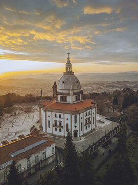 Aerial view of the Santuario de Nossa Senhora do Sameiro bathed in the warm glow of sunset, its dome and facade standing majestically, Braga, Braga, Portugal.