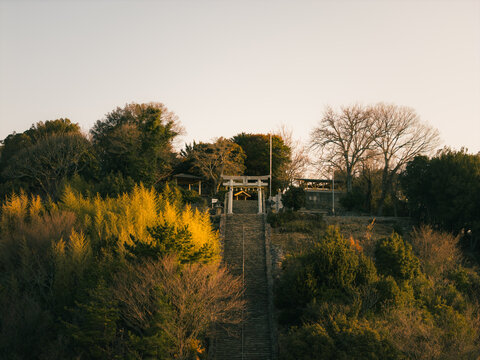 Aerial view of Takaya Shrine standing majestically atop a hill, its torii gate a beacon against the landscape, Kanonji, Kagawa, Japan.