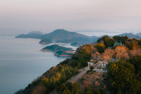 Aerial view of Takaya Shrine gate perched high above the Seto Inland Sea, with islands fading into the horizon, Kanonji, Kagawa, Japan.