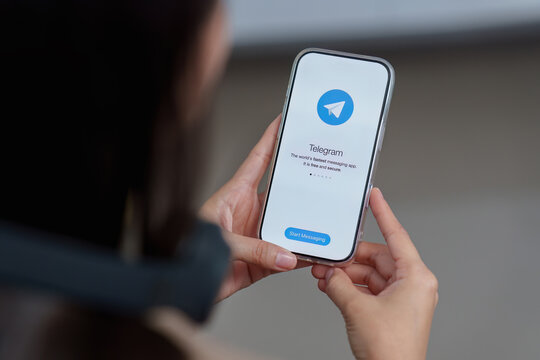 CHIANG MAI, THAILAND, MAR 18 , 2026 : Woman hand holding iPhone 17 with social networking service Telegram on the screen.