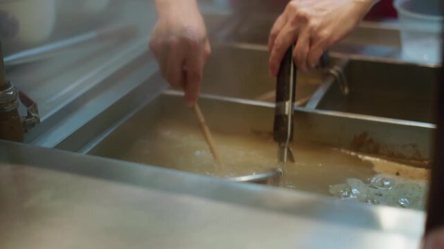 Noodles are cooked in a noodle strainer to make ramen. Delicious Asian street food.