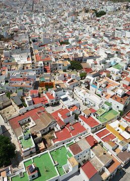 Aerial view of sun-drenched white buildings with terracotta rooftops create a captivating mosaic against the clear blue sky, Vejer de la Frontera, Andalusia, Spain.