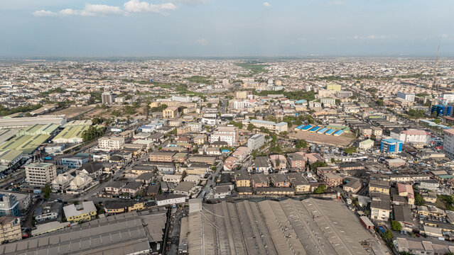 Aerial view of the sprawling urban landscape, where rooftops meet the horizon under a vast sky, Ogba, Lagos, Nigeria.