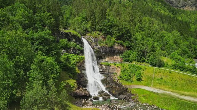 Drone aerial view of Steinsdalsfossen waterfall surrounded by lush forest in western Norway.