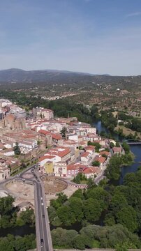 Vertical aerial orbit capturing the city of Plasencia near the Jerte River in C&aacute;ceres, highlighting the urban landscape and surrounding scenery.