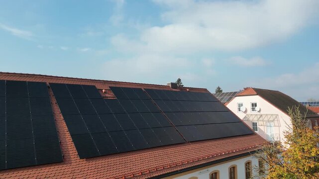 Solar panels on residential rooftop houses in a Bavarian town, photovoltaic installation for clean electricity, sustainable housing and modern home power generation in Germany