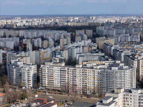 Aerial view of densely packed apartment buildings stretch across the horizon under a pale sky, a concrete tapestry woven with roads, Bucharest, Bucharest, Romania.